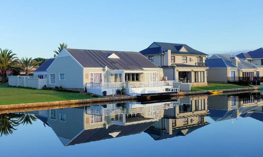 Modern luxury waterfront villa with private dock and lake views at sunset